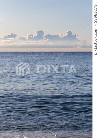 Calm morning at empty beach with a car tyre prints on sand, with sea and clouds at the background 59963279