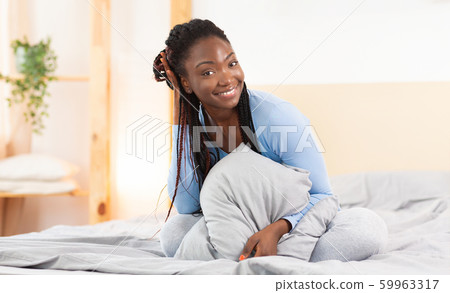 Black Girl Smiling At Camera Sitting In Comfortable Bed Black Girl Smiling At Camera Sitting In Comfortable Bed 59963317