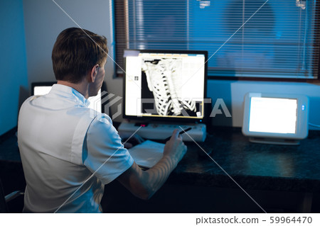 in medical laboratory patient undergoes MRI or CT scan process under Supervision of Radiologist in Control Room, He Watches Procedure and Monitors skeleton and ribs of the patient in medical laboratory patient undergoes MRI or CT scan process under Supervision of Radiologist in Control Room, He Watches Procedure and Monitors skeleton and ribs of the patient 59964470