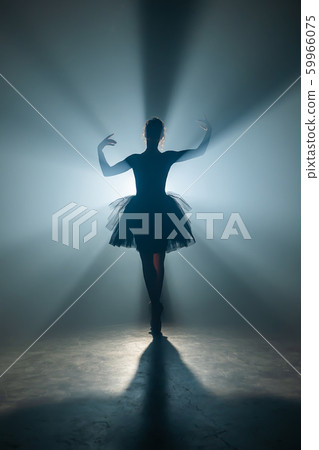 Solo performance by ballerina in tutu against backdrop of luminous spotlight Solo performance by ballerina in tutu against backdrop of luminous spotlight 59966075