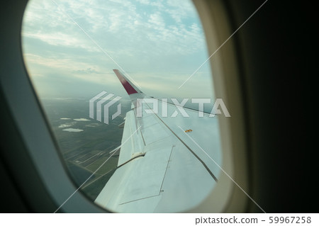 Aiplane windows view on aircraft wing from the cabin, skyline transportation Aiplane windows view on aircraft wing from the cabin, skyline transportation 59967258