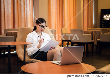 Businesswoman Using Laptop In Airport Departure Lounge 59967784