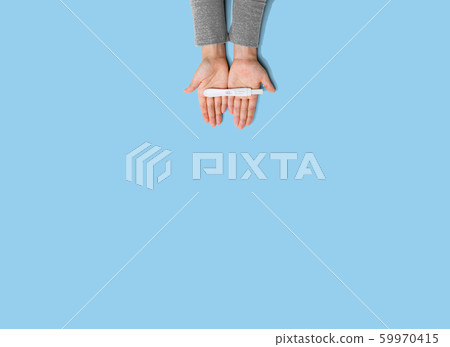 Woman holding a positive pregnancy test Woman holding a positive pregnancy test 59970415