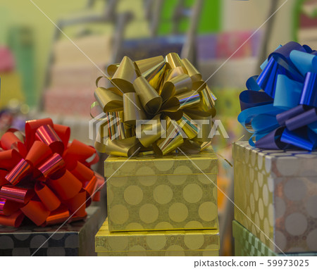 christmas or birthday gifts present golden box with blue red and gold ribbon close up on defocused background christmas or birthday gifts present golden box with blue red and gold ribbon close up on defocused background 59973025