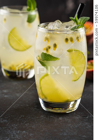 Green Lemonade drink or Mojito coctail with lime, mint, passion fruit and ice on black table. 59974186