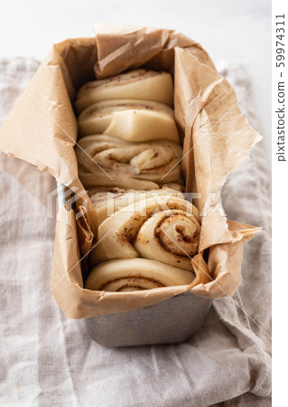 Raw cinnamon bread in a baking dish. Copy space. 59974311
