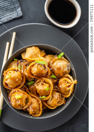 Asian dumplings in bowl, chopsticks, plates. Asian table setting. Chinese dumplings for dinner. Selective focus. Asian style decoration. Chinese fresh homemade food. Closeup 59975111