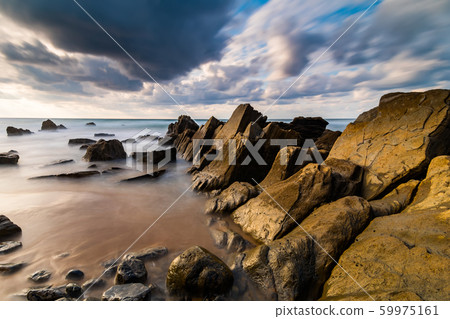 Flysch rocks in Barrika beach at the sunset. Travel in Spain. Flysch rocks in Barrika beach at the sunset. Travel in Spain. 59975161