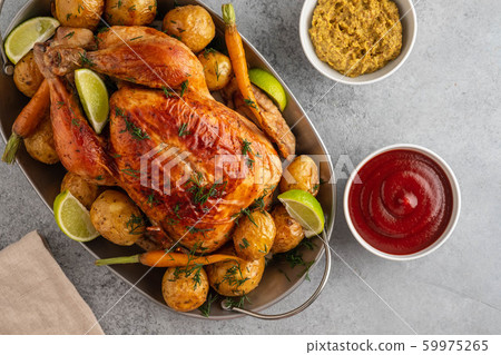 Chicken baked with potatoes, lime and herbs in grey pan. Top view. Chicken baked with potatoes, lime and herbs in grey pan. Top view. 59975265
