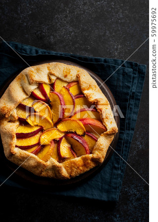 Plate with delicious peach galette on black background. Copy space. 59975692