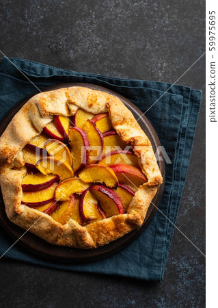 Plate with delicious peach galette on black background. Copy space. 59975695