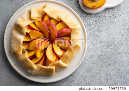 Appetite summer peach galeta on white table with copy space. summer open tart photo for cook book or food blog. 59975789