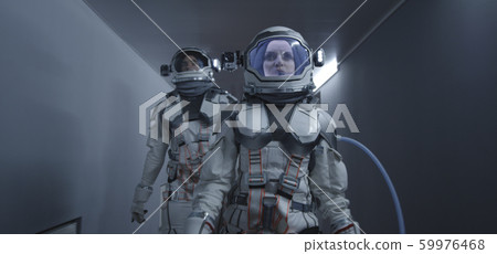 Astronauts walking down a corridor 59976468