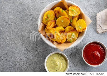 Baked potato wedges with cheese and herbs and tomato sauce on grey background - homemade organic vegetable vegan vegetarian potato wedges snack food meal. 59976584