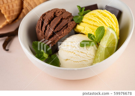 Trio of tasty chocolate vanilla and lime flavored frozen dessert in a white bowl. 59976678
