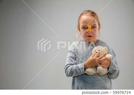 Caucasian girl wearing the respiratory protection pin clasp against air pollution and dusk on grey studio background Caucasian girl wearing the respiratory protection pin clasp against air pollution and dusk on grey studio background 59976724
