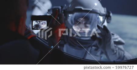 Astronaut filming spacewalking crewmate Astronaut filming spacewalking crewmate 59976727