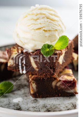 Chocolate brownie with vanilla ice cream, rasberry and mint on a white background. Copy space. Chocolate brownie with vanilla ice cream, rasberry and mint on a white background. Copy space. 59976795