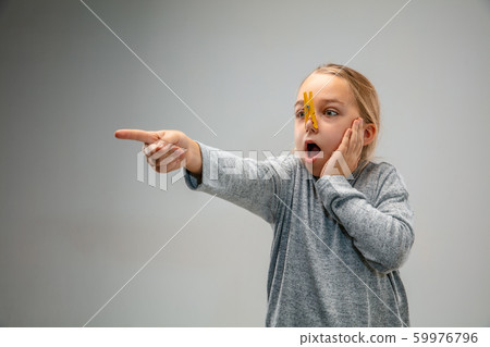 Caucasian girl wearing the respiratory protection pin clasp against air pollution and dusk on grey studio background Caucasian girl wearing the respiratory protection pin clasp against air pollution and dusk on grey studio background 59976796