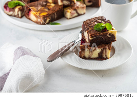 Cheesecake brownies with raspberry stacked on a white plate. Cheesecake brownies with raspberry stacked on a white plate. 59976813