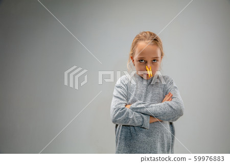 Caucasian girl wearing the respiratory protection pin clasp against air pollution and dusk on grey studio background Caucasian girl wearing the respiratory protection pin clasp against air pollution and dusk on grey studio background 59976883