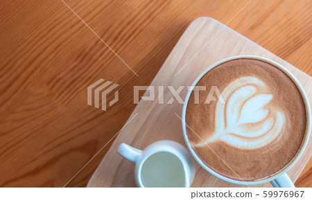 Latte coffee cup with latte art on wooden table in 59976967