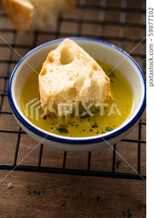 Freshly baked white bread with olive oil and herbs on wooden background. 59977102