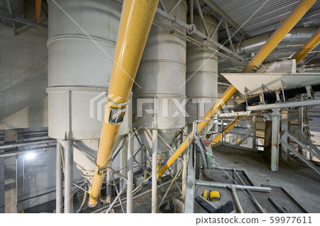Large industrial mixer, for mixing ingredients into liquid cement.. Workers in the workshop of the Large industrial mixer, for mixing ingredients into liquid cement.. Workers in the workshop of the 59977611