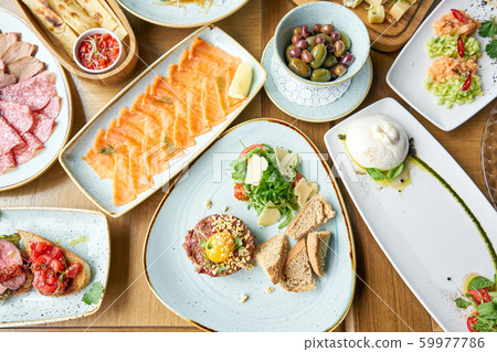 Beef tartar in the restaurant. Variety of dishes on the table. Various snacks and antipasti on the Beef tartar in the restaurant. Variety of dishes on the table. Various snacks and antipasti on the 59977786