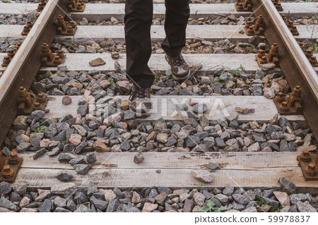 Man walking on the railway tracks 59978837