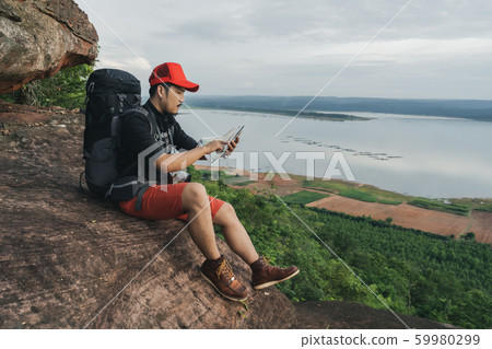 man traveler with backpack looking at the map on man traveler with backpack looking at the map on 59980299