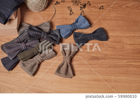 Bow ties made of wool on oak wooden table, adds a finished product. Small craft production Bow ties made of wool on oak wooden table, adds a finished product. Small craft production 59980810