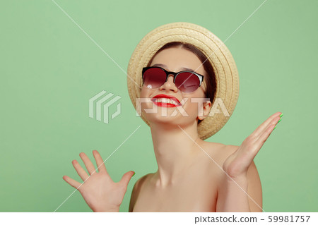 Portrait of beautiful young woman with bright make-up isolated on green studio background Portrait of beautiful young woman with bright make-up isolated on green studio background 59981757