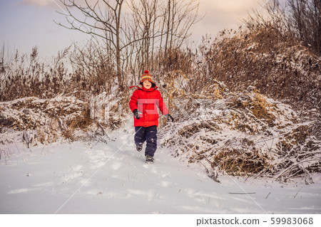 Cute boy in red winter clothes runs fun in the snow. Winter Fun Outdoor Concepts 59983068