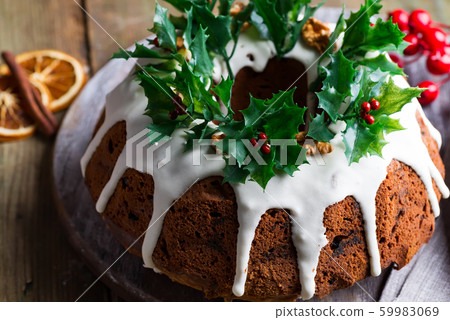 Christmas chocolate cake with white icing and pomegranate kernels on a wooden dark background 59983069