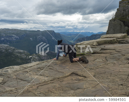 Lying men looking view on fjord Lysefjord over the 59984501