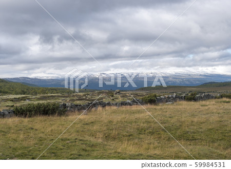 Autumn view on hills and snow capped mountains Autumn view on hills and snow capped mountains 59984531