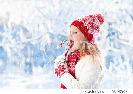 Child with candy cane on winter fair 59985023