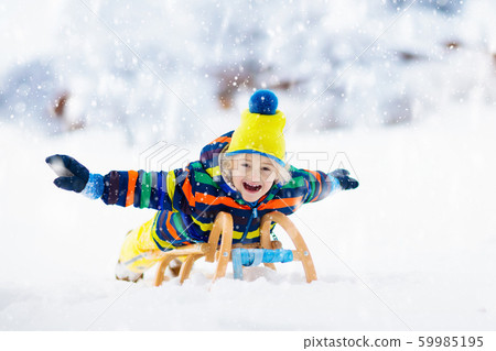 Boy on sled ride. Child sledding. Kid on sledge 59985195