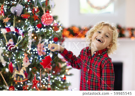 Child decorating Christmas tree. Kid on Xmas eve. 59985545