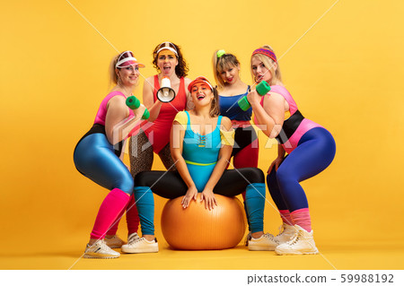 Young caucasian plus size female models training on yellow background Young caucasian plus size female models training on yellow background 59988192