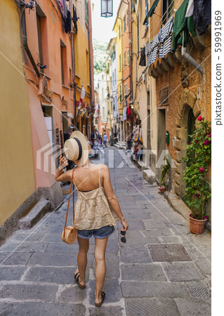 Back view of tourist woman walking in italian 59991969