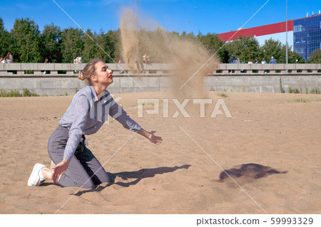 Young girl plays with sand on a summer sunny day 59993329