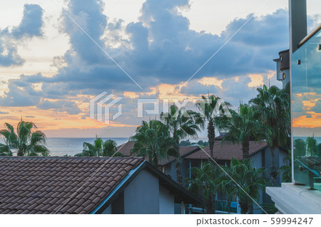 Mediterranean seaside with view of houses roofs with red tile and greenery in the evening, Background is sea, Alanya, Turkey. Travel concept. Mediterranean seaside with view of houses roofs with red tile and greenery in the evening, Background is sea, Alanya, Turkey. Travel concept. 59994247