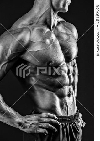Beautiful naked male torso against black background Beautiful naked male torso against black background 59995658