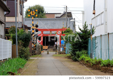 Scenery with a railroad crossing in front of torii 59997323