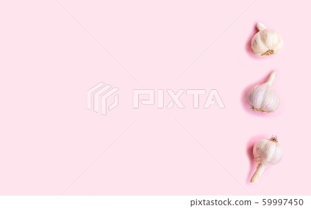 Three heads of fresh garlic on a pink background, 59997450