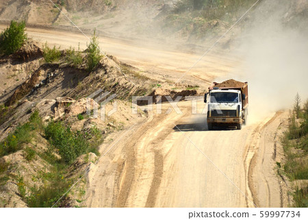 Dump truck transports sand and other minerals in the mining quarry. Dump truck transports sand and other minerals in the mining quarry. 59997734