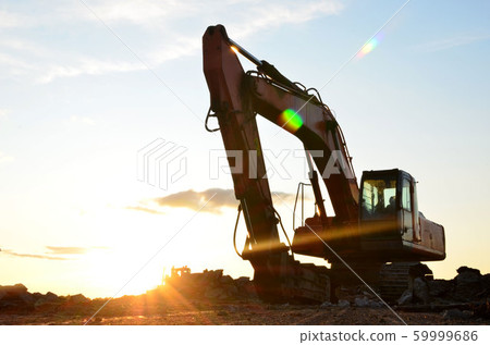 Large tracked excavator digs the ground for the foundation and construction of a new building 59999686