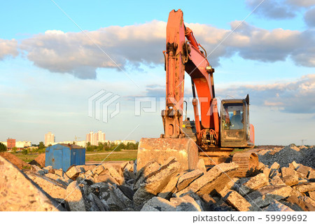 Large tracked excavator digs the ground for the foundation and construction of a new building  59999692